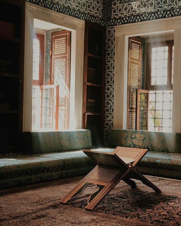 A quiet mosque reading corner with a traditional Quran stand