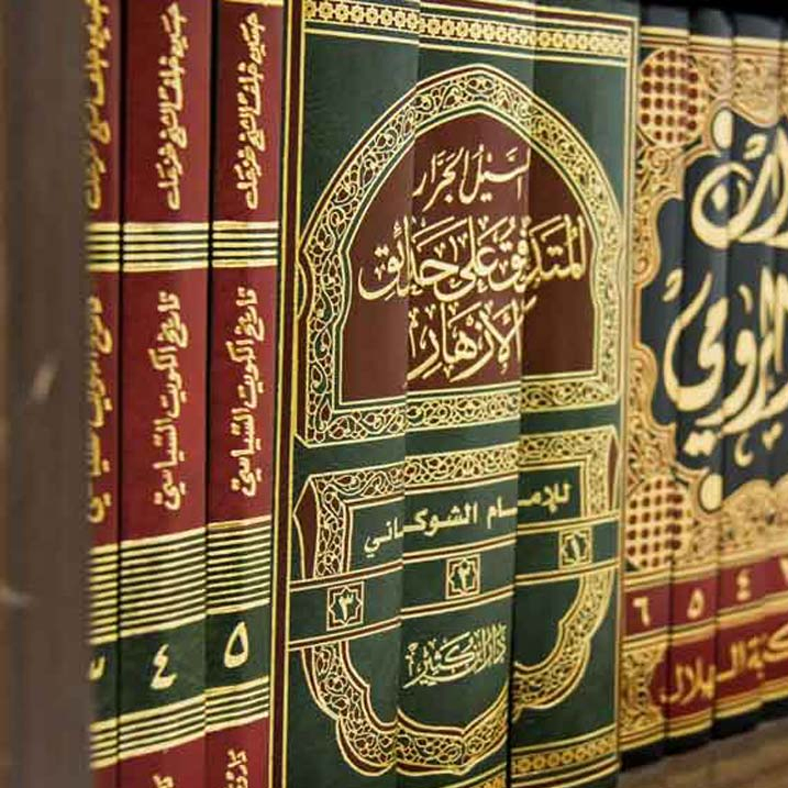 Classical Arabic Islamic texts on a bookshelf